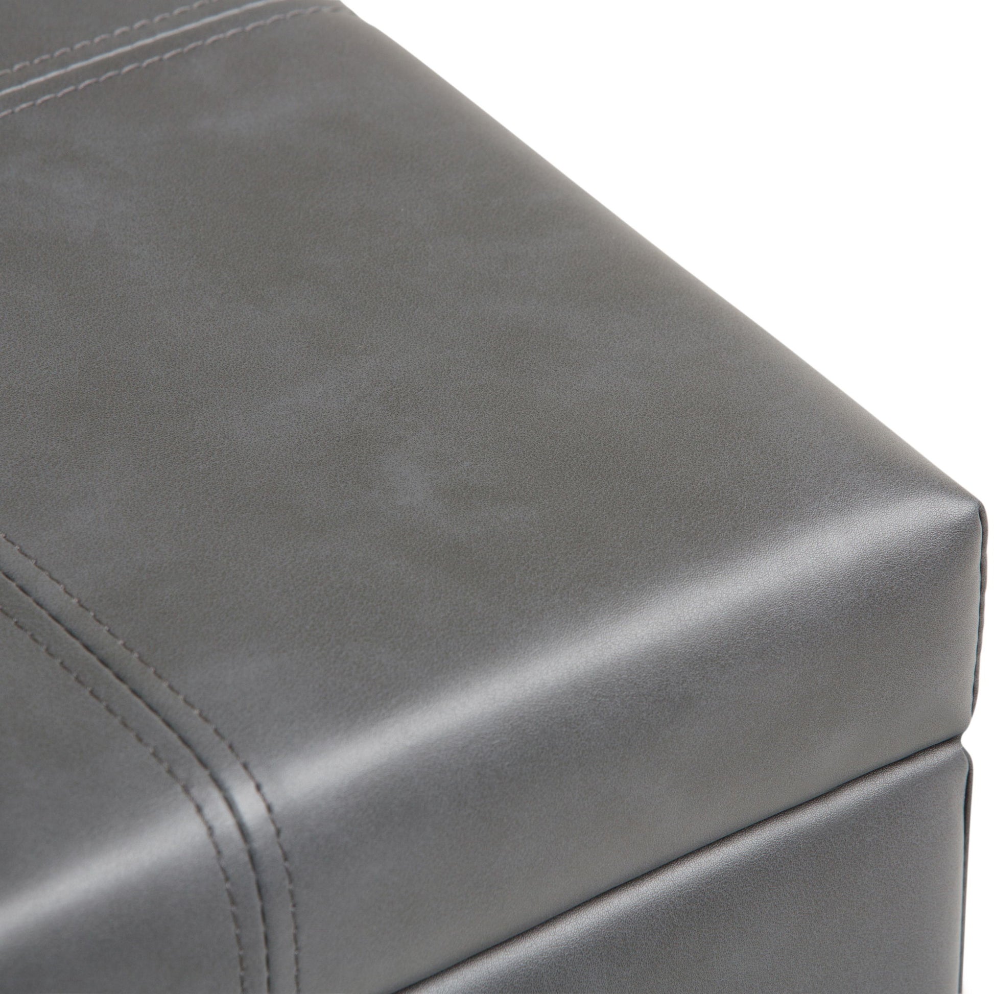 Close-up of the Dover Upholstered Storage Ottoman Bench in gray leather, showcasing visible stitching and a smooth, matte surface.