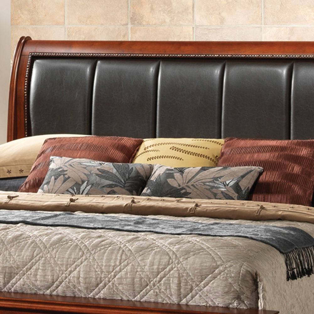 A neatly made Lavita Storage Bed with a dark, padded leather headboard, beige quilted blanket, brown and patterned throw pillows, plus a tan and yellow accent pillow, set against a tiled wall.