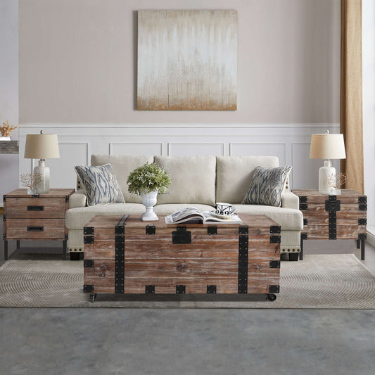 A cozy living room featuring the Trunk Table and Side Table with Large Storage (Set of 3) in Antique Gray, paired with a beige sofa, patterned pillows, soft lighting, a plant centerpiece, and neutral wall art above the sofa.