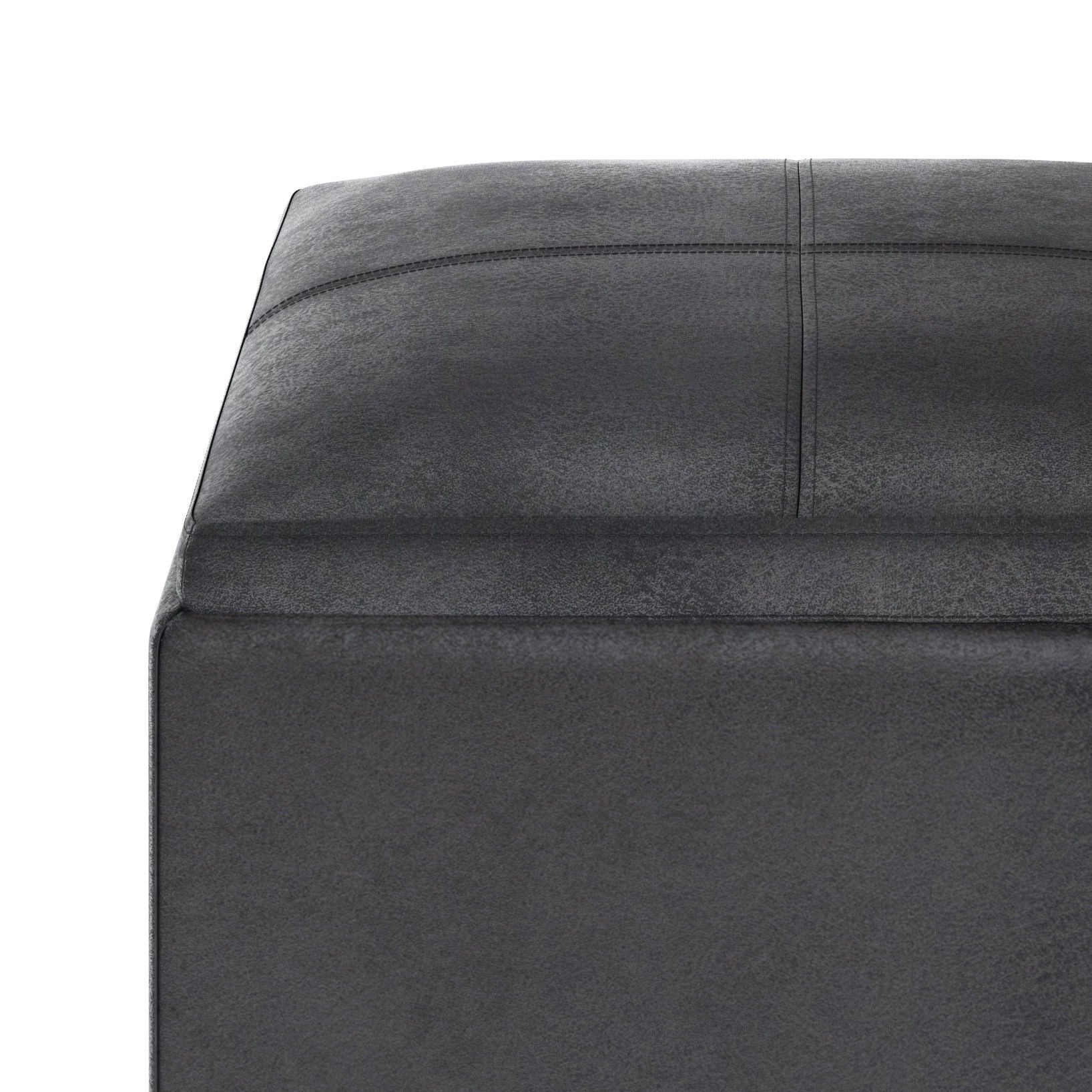 Close-up of the corner of the Rockwood Upholstered Cube Storage Ottoman With Tray in dark gray, showing its square shape and visible stitching on top and sides, set against a white background.