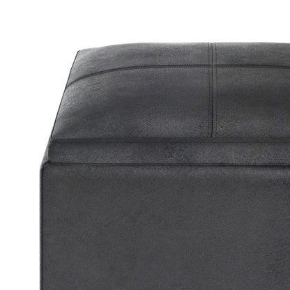 Close-up of the corner of the Rockwood Upholstered Cube Storage Ottoman With Tray in dark gray, showing its square shape and visible stitching on top and sides, set against a white background.