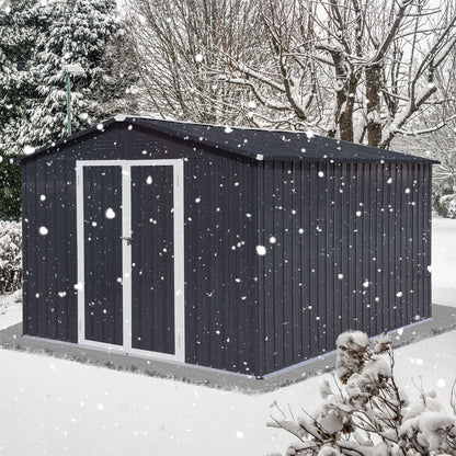 A 10'x12' Garden Sheds Outdoor Storage Shed with white trim sits on a concrete base in a snowy yard, surrounded by leafless trees and snow-covered bushes as snow falls.