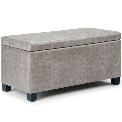 The Dover Upholstered Storage Ottoman Bench features a cushioned lid in light gray faux leather and short black legs, shown against a white background.