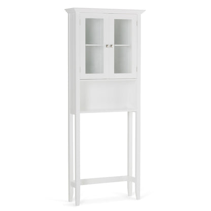 The Acadian Space Saver Cabinet in Pure White features glass double doors, two small knobs, an open lower shelf, and tall legs designed to fit conveniently over a toilet.