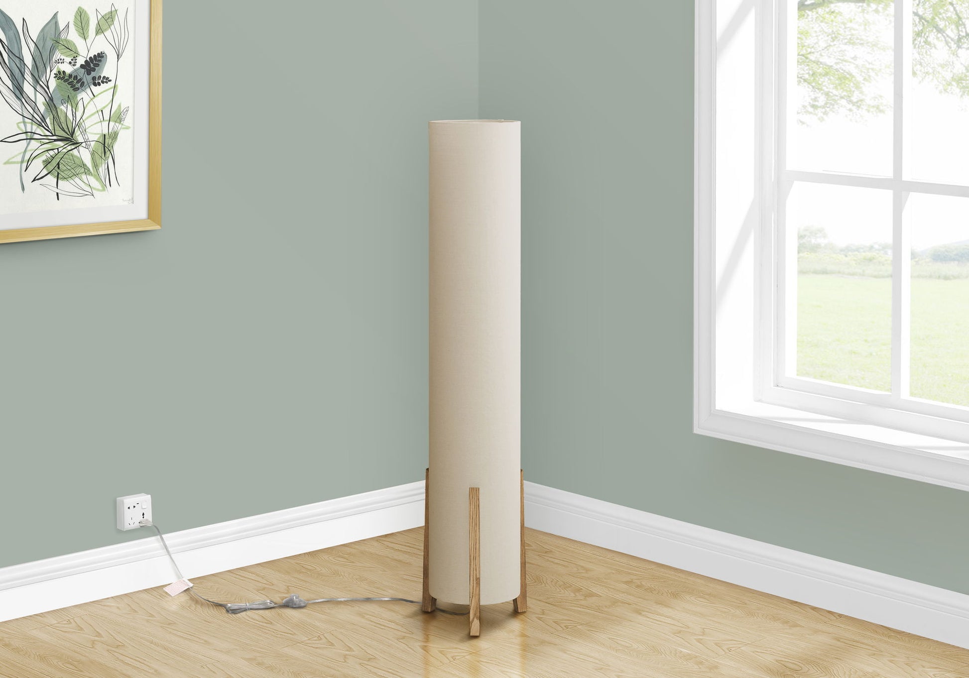 A contemporary brown floor lamp with a wood look stands in the corner of a light green room by a window facing grass, near a framed botanical print. The lamp is plugged into a wall outlet.