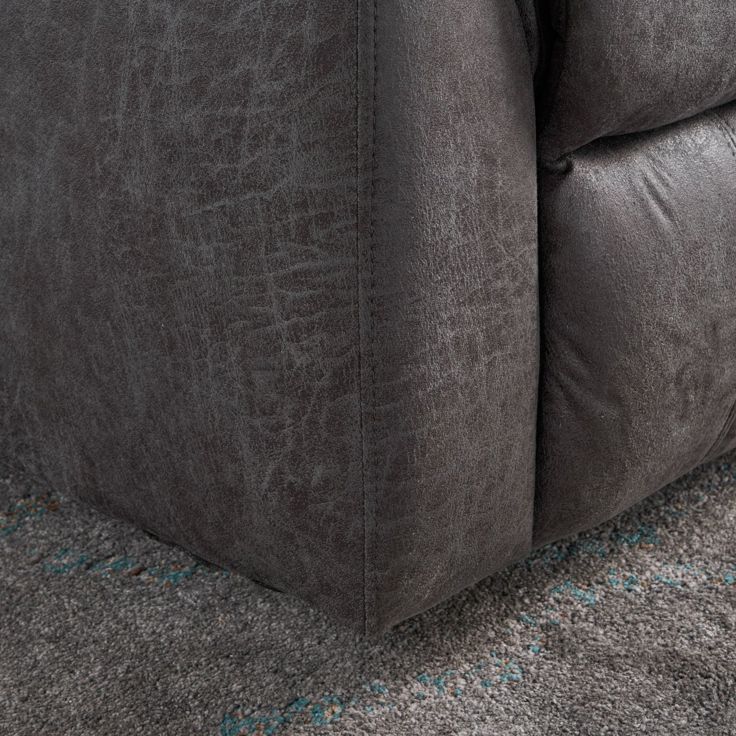 Close-up of the bottom corner of the Contemporary Glider Recliner With Swivel Function, upholstered in dark gray fabric, resting on a textured gray carpet with subtle blue accents.