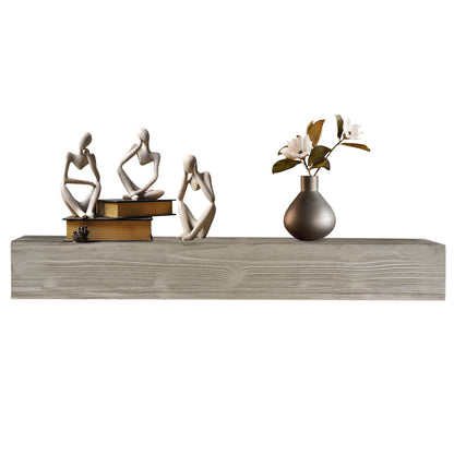A Rustic Wood Fireplace Mantel, Wall-Mounted & Floating Shelf displays three abstract human figurines, a small stack of books, a pinecone, and a gray vase filled with white flowers and green leaves.