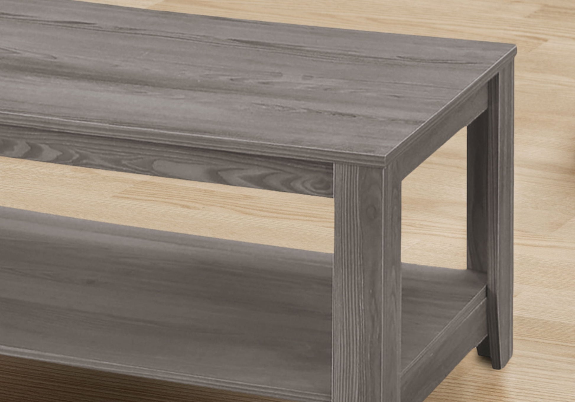 A close-up of the gray Table Set, Coffee, End, Side, Accent, Transitional (Set of 3), featuring a rectangular design with visible wood grain and a lower shelf, displayed on a light wood floor.
