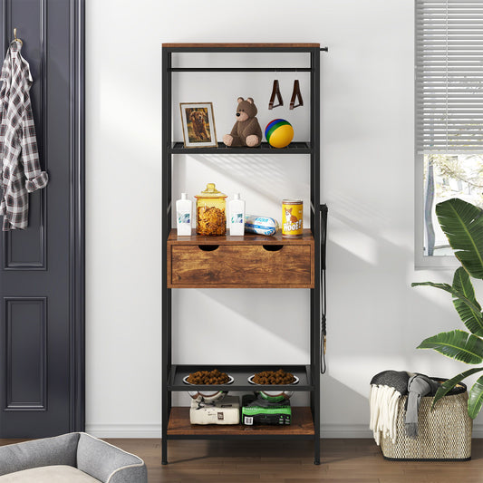 A tall Dog Feeding Station with 3 height adjustable raised dog bowls and shelves in black/dark brown holds framed photos, a teddy bear, toys, snacks, drinks, and pet food. Clothes and a laundry basket are nearby, with a plant and window to the right.