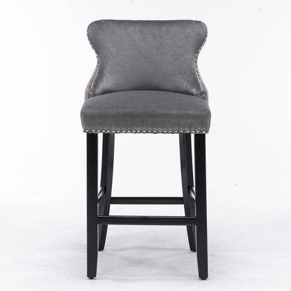 Contemporary velvet upholstered wing-back barstools with button tufted decoration, chrome nailhead trim, and wooden legs, shown in a set of 2 against a plain white background.