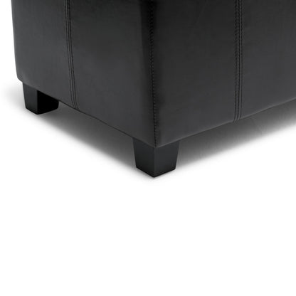 Close-up of the bottom corner of the Dover - Upholstered Storage Ottoman Bench in black leather with dark wooden legs, set on a white background.