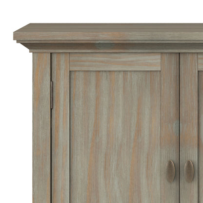 Close-up of the top left corner of the Redmond Handcrafted Low Storage Cabinet, showing its distressed gray finish, two doors with vertical handles, and visible wood grain texture.