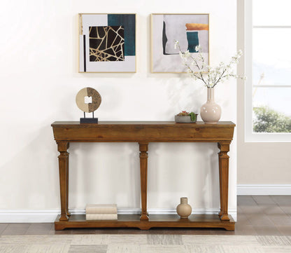 The Garrison Wooden Console Table sits against a white wall, styled with books, vases, and a round sculpture beneath two abstract framed artworks.