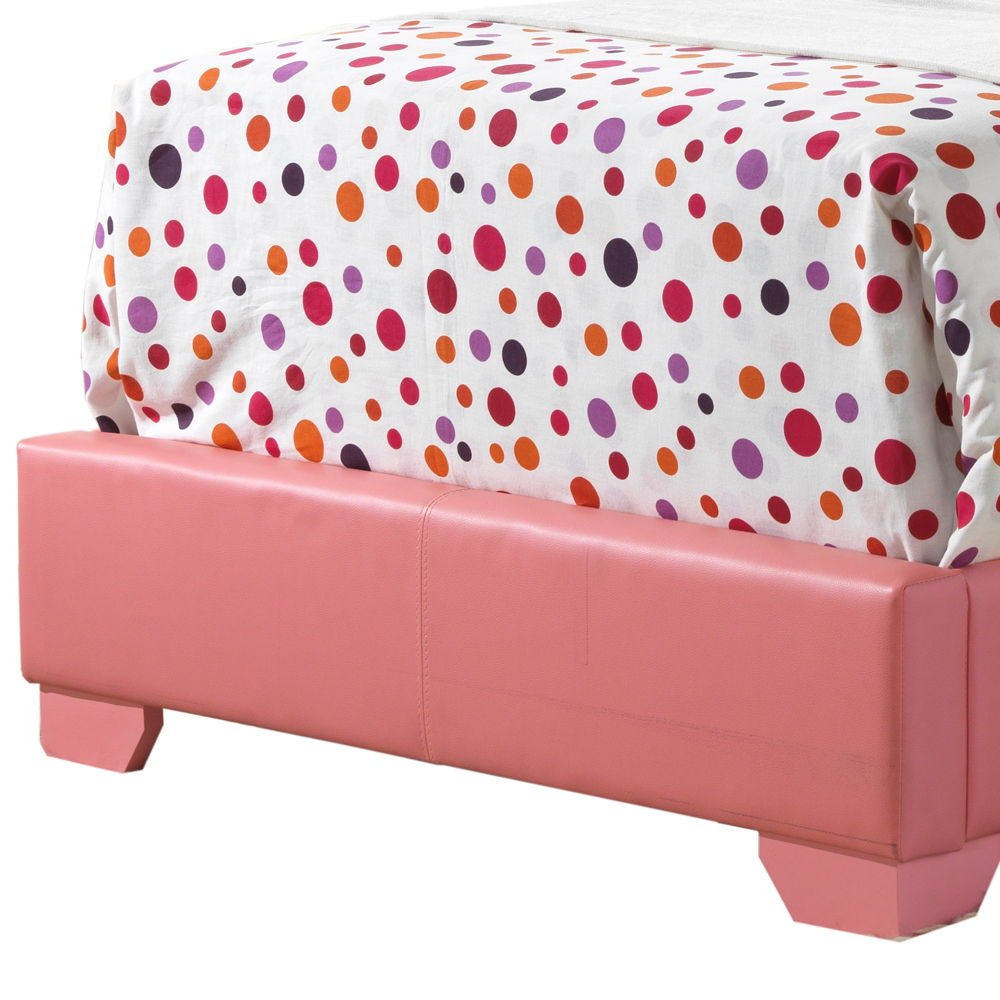 An Elegant Platform Bed For Relaxed Spaces is topped with a white comforter featuring orange, red, and purple polka dots in various sizes, while a pink upholstered bench sits at its foot.