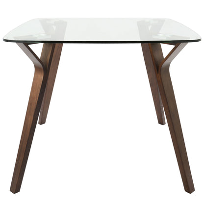The Folia - Mid Century Modern Dinette Table features a clear glass top and four dark-finished, angled wooden legs, shown from the front.