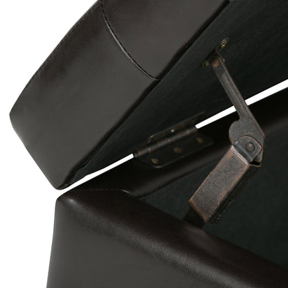 Close-up view of the Cosmopolitan - Upholstered Storage Ottoman in dark brown leather with its lid open, revealing the metal hinge and support mechanism inside.