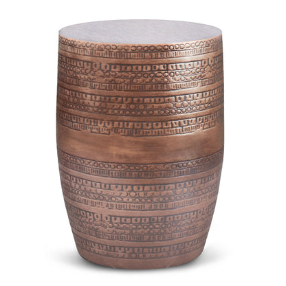 The Johnsen - Handcrafted Large Metal Accent Table is a cylindrical metal stool or side table with a bronze finish, engraved horizontal geometric and dotted bands for added style.