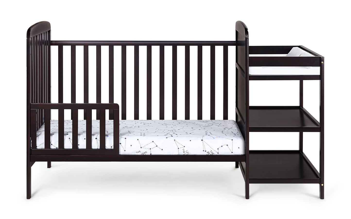 The Ramsey 3-in-1 Convertible Crib/Changer Combo is a dark wood crib with an attached changing table, two open storage shelves, and includes a white mattress with a subtle pattern.