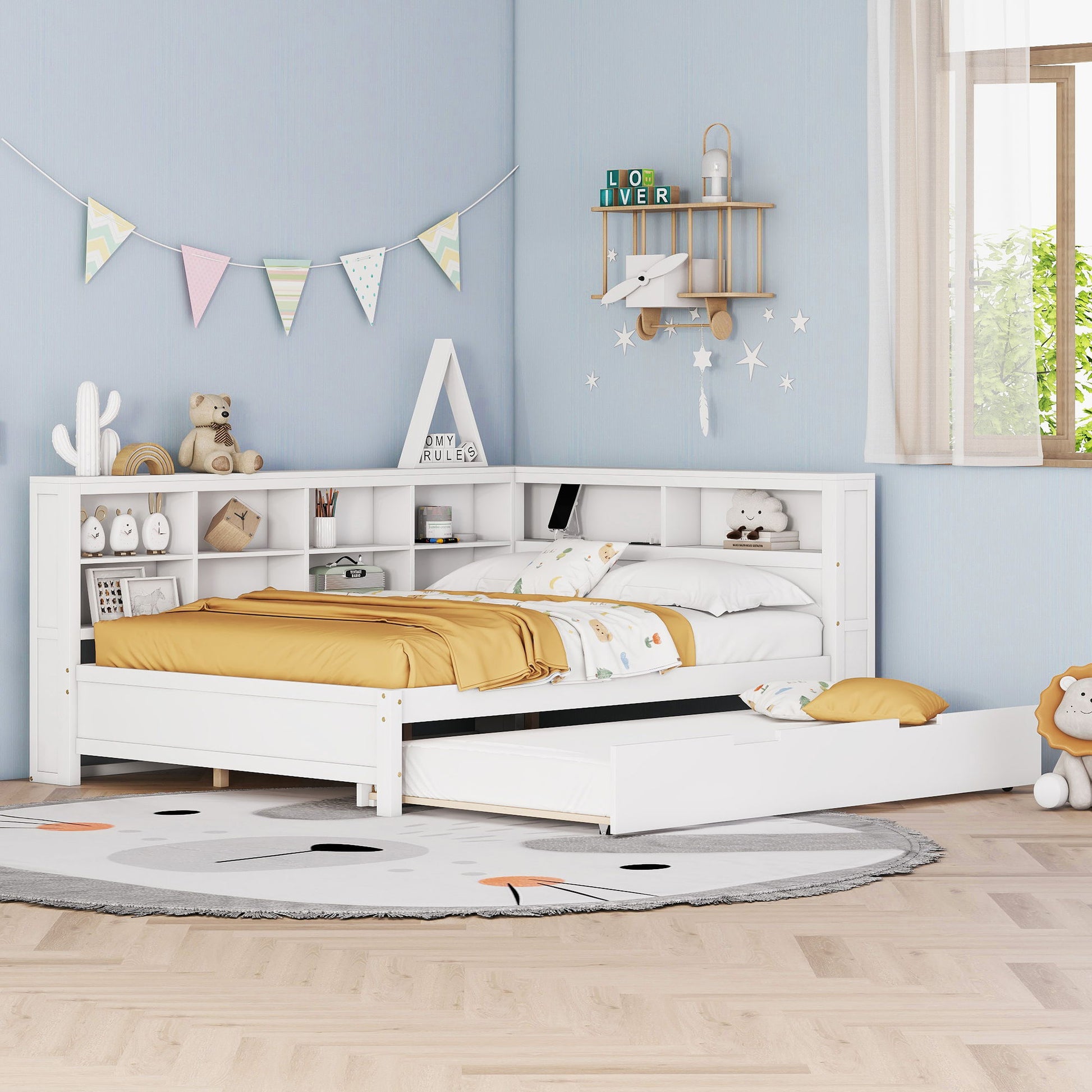 A tidy children's bedroom features a white Wooden Full Size Daybed with Twin Size Trundle, storage shelf, and USB charging ports, styled with yellow and white bedding, soft toys, wall shelves, bunting, and a round animal-themed rug on a light wooden floor.