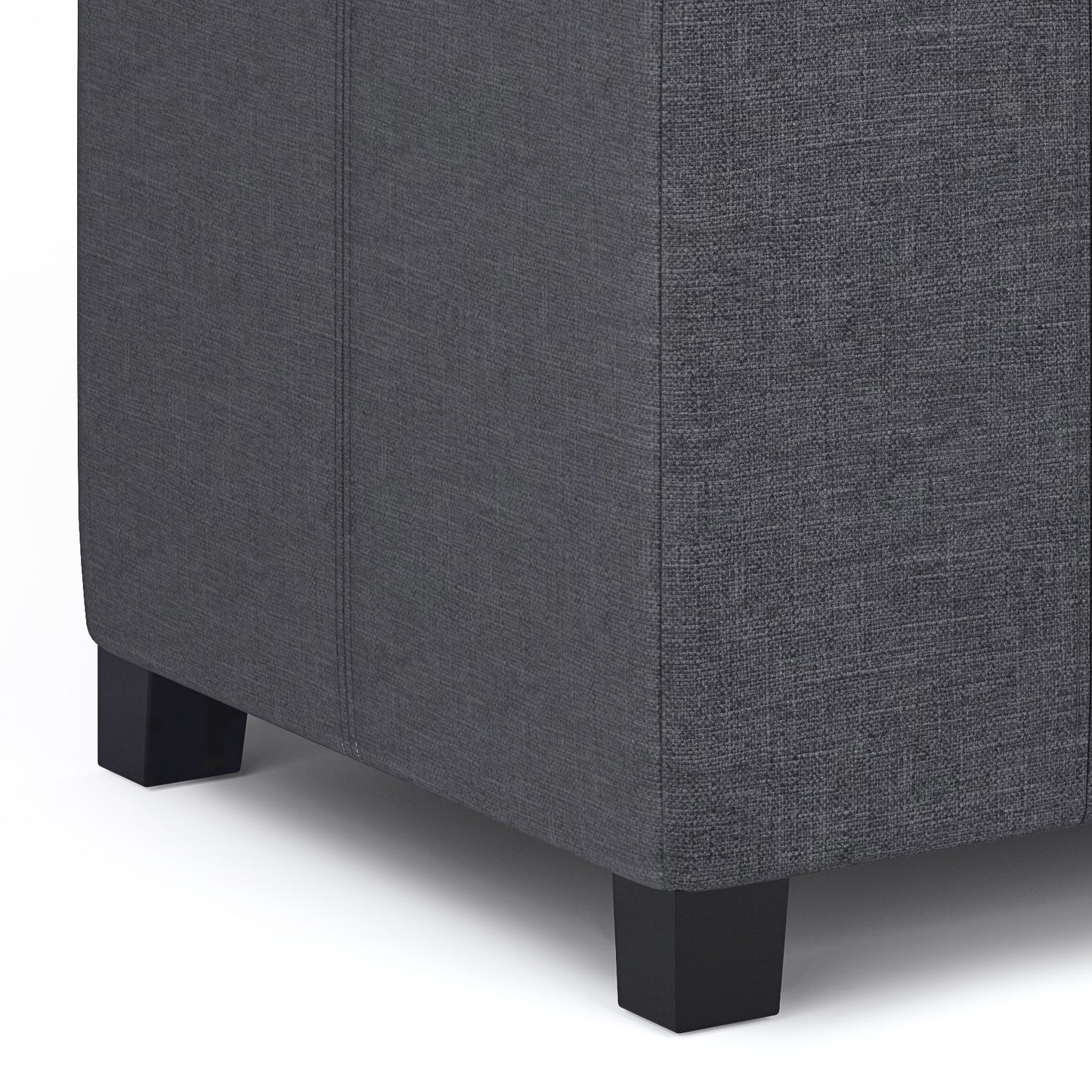 Close-up of the lower corner of the Dover - Upholstered Storage Ottoman Bench in dark gray textured fabric with short black square legs, shown against a white background.