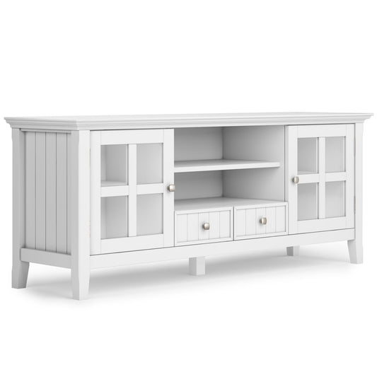The Acadian TV Media Stand features a classic white paneled design, glass-paneled doors on each side, two center open shelves, two small drawers below, and stands on short legs.