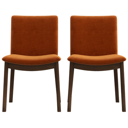 Two Laura mid-century modern dining chairs sit side by side against a white background, featuring orange velvet upholstery and dark brown wooden legs.