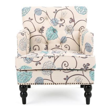 Front view of the Vitality Club Chair, featuring beige upholstery with blue and gray floral patterns, button-tufted diamond stitching on the backrest, rounded armrests, and black turned wooden legs.
