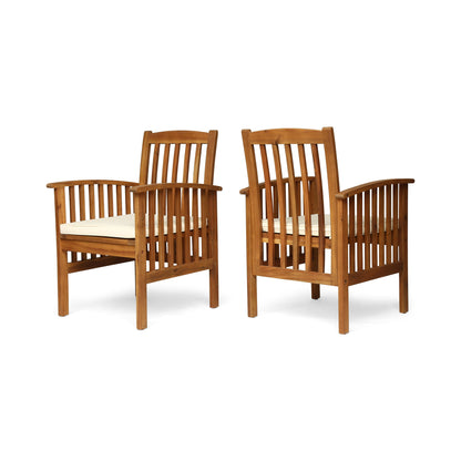 The Casa Acacia Dining Chair Set With Cushions includes two wooden chairs with vertical slat backs and sides, light-colored seat cushions, and are displayed at an angle to show both front and side views.