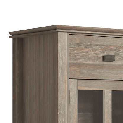 Close-up of the upper corner of the Artisan - Handcrafted Sideboard Buffet, showing a weathered finish, a small drawer with a rectangular handle, and glass-paneled doors below.