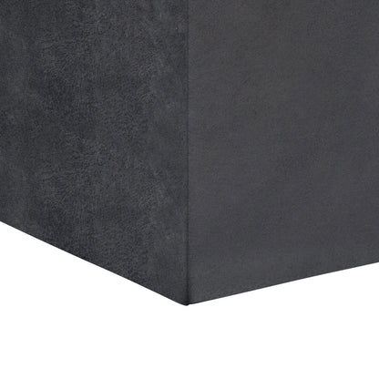 Close-up view of the corner of a dark gray Rockwood Upholstered Cube Storage Ottoman With Tray, set against a plain white background.