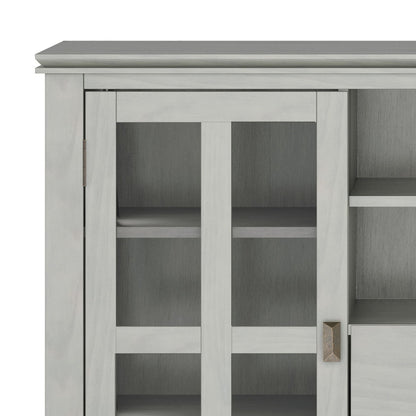 Cropped view of the Artisan Handcrafted Tall TV Media Stand in light gray, featuring a glass-paneled door with a grid-frame design, metal handle, and visible interior shelves.