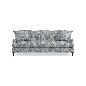 Introducing the Sanderson x Giles Deacon Bedford 87" Sofa, showcasing a captivating floral pattern in shades of blue and white. This sofa boasts cushioned seating and backrest, elegant curved armrests, and is supported by dark wooden legs. Its design is accentuated by intricate fabric detailing.