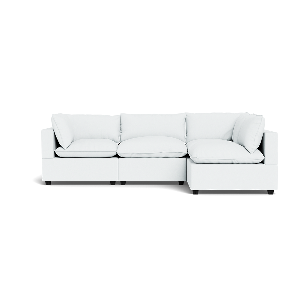 The Kova Pillow Cushion L-Shape is a modern, white modular sectional sofa with plush seat and back cushions, shown against a plain white background.
