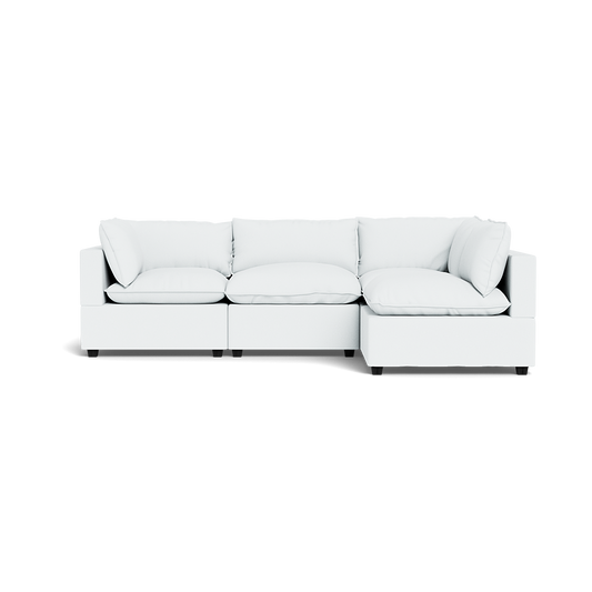 The Kova Pillow Cushion L-Shape is a modern, white modular sectional sofa with plush seat and back cushions, shown against a plain white background.