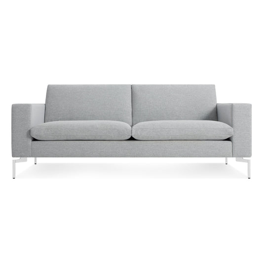 The New Standard 78" Sofa in Maharam Mode Intaglio/White features a modern light gray design with straight armrests, plush seat and back cushions, and white metal legs, displayed against a plain white background.