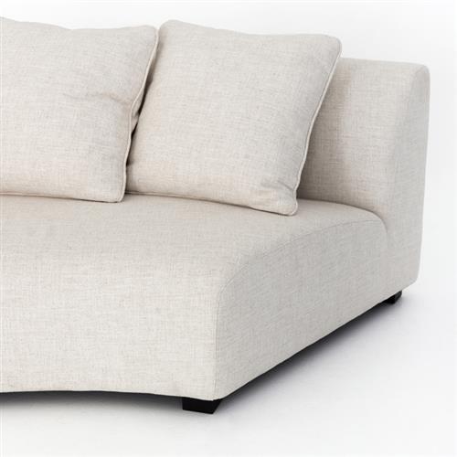 A white sectional sofa corner with two large cushions, featuring a minimalist design and upholstered in a textured fabric, is positioned on a light-colored surface. This stylish piece is part of the Zoe Modern Performance Black Birch Wood Curved Sectional.